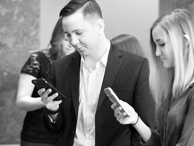 A couple using mobile phones at a fundraising events to place bids via auction software